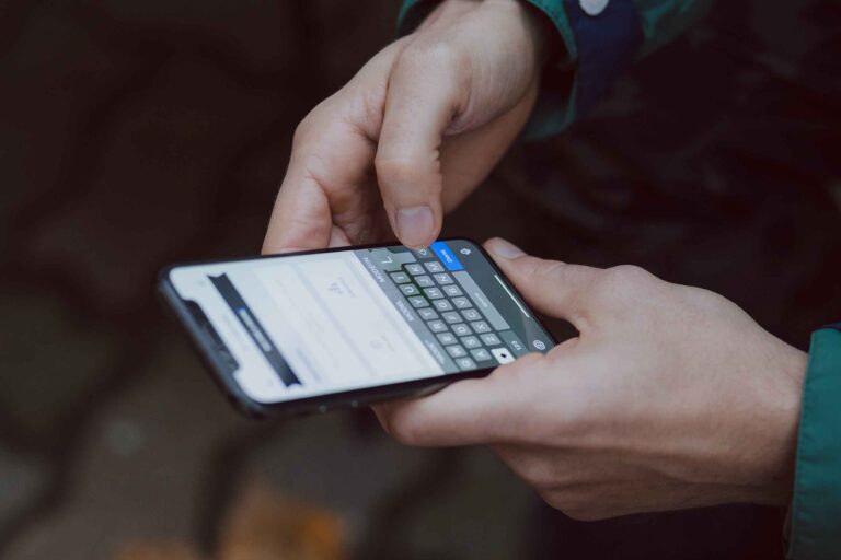 a person holding a phone and typing on an app