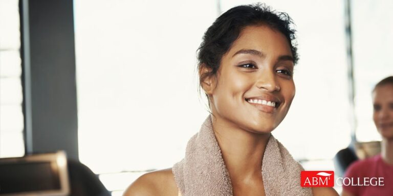 a woman working out smiling with a towel around her neck