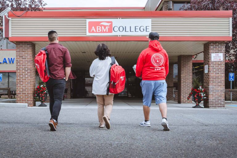 a group of people walking towards ABM College building