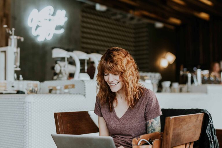 a woman sitting at a table with a laptop
