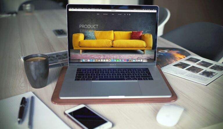 a laptop that shows a website with a sofa as a product and surrounded by different items