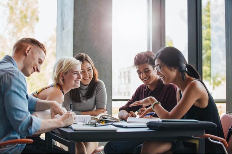 a group of students talking and studying together