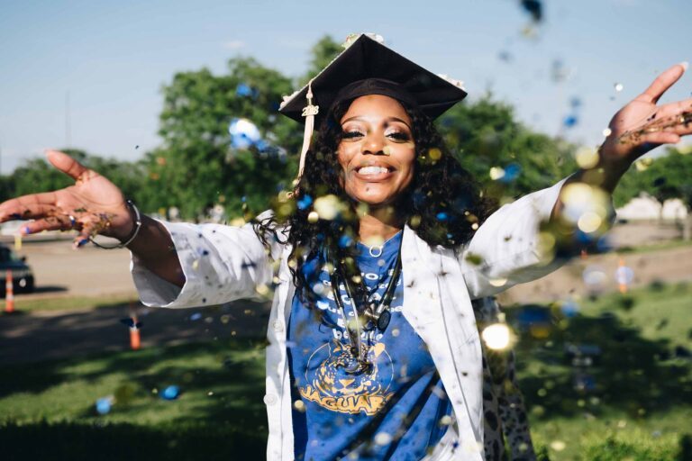 a women throwing confetti while wearing graduation hat and stethoscope