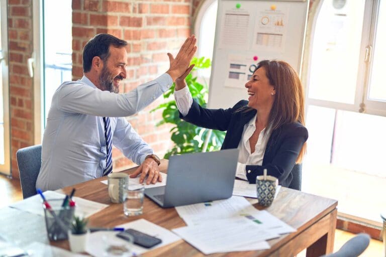 a man and woman high-fiving while laughing