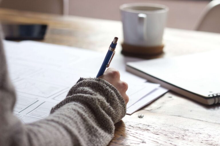 a person writing on a piece of paper
