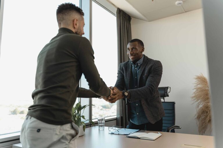 two people shaking hands in an office