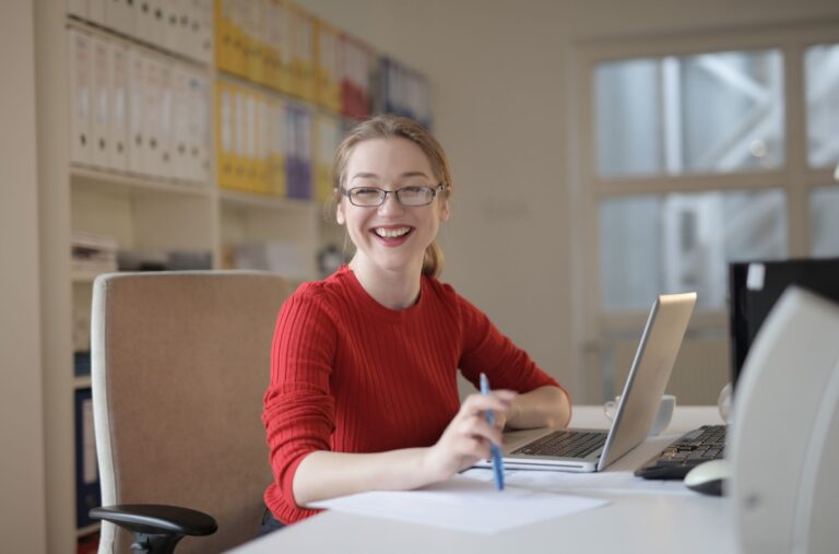 a woman smiling and sitting on a chair for a picture
