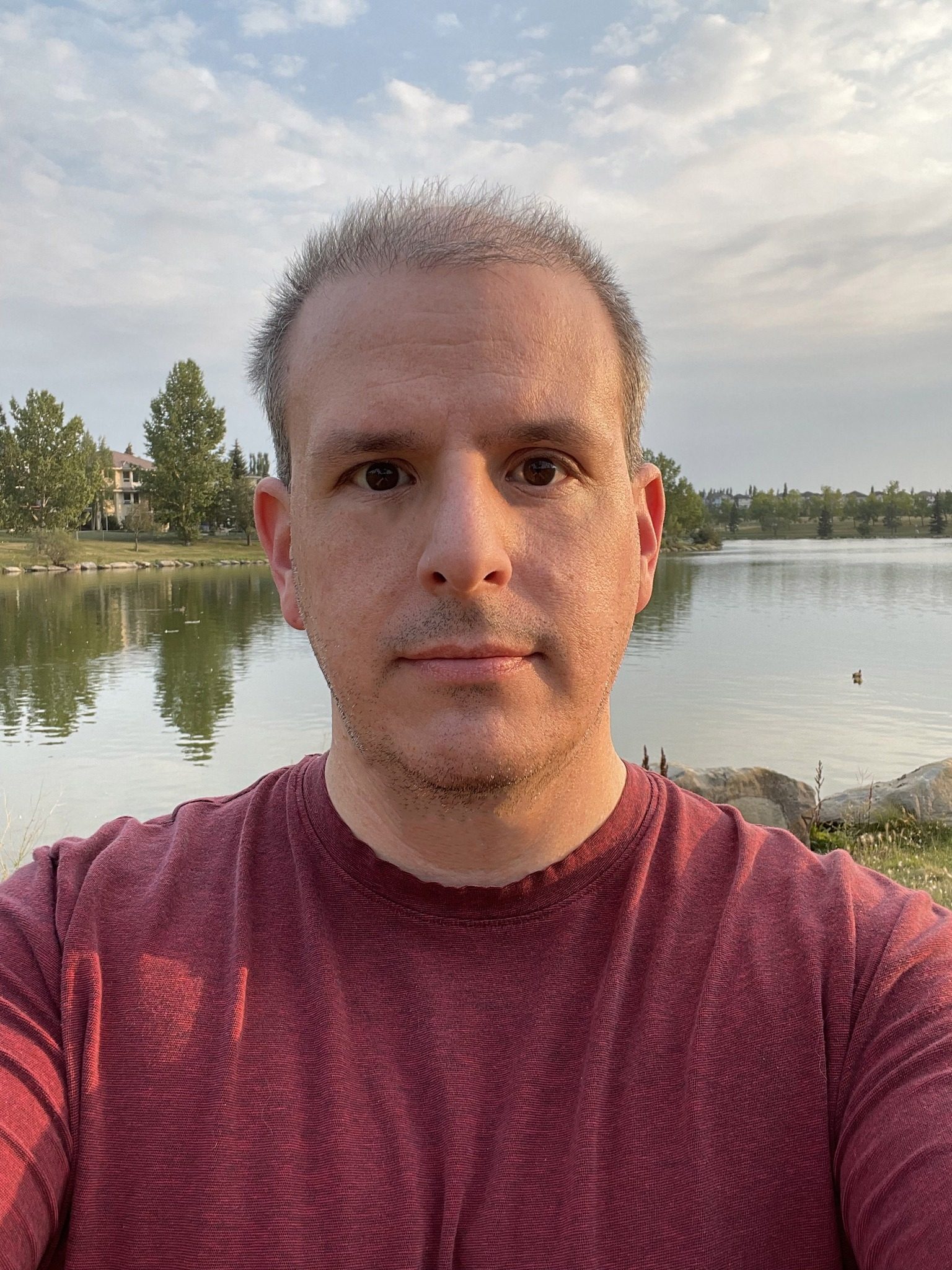 a man taking a selfie by a lake