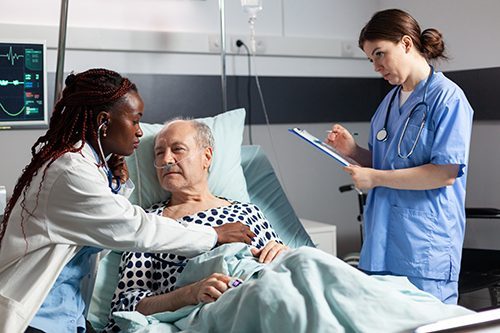 A doctor conducts a physical exam on a elderly patient as an MOA records results