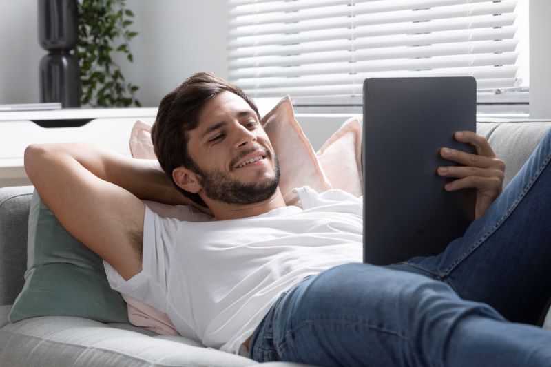 An employee working from home reading emails on his tablet knowing that they are secure